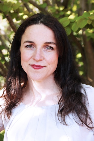 Portrait of Louise Gray, a young woman with shoulder length brown hair and dark eyes wearing a white blouse.