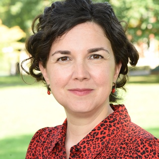 A woman with short, dark hair and dark eyes looking directly at the camera.