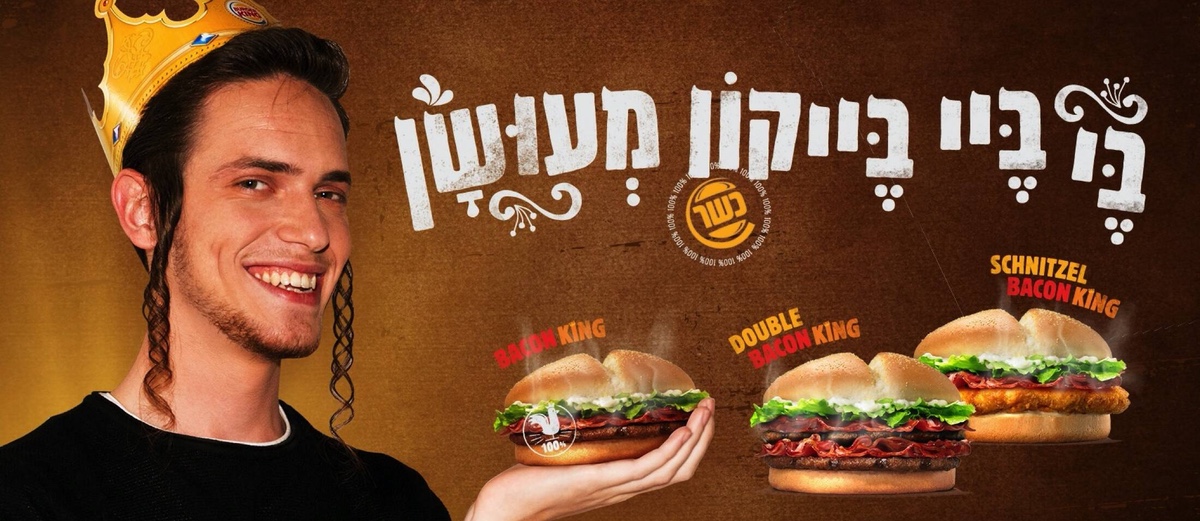 An advertisement for Burger King kosher "bacon" in Israel. A smiling young man wearing a Burger King paper crown holds a "bacon" burger. He has the long sidelocks that signify an observant religious Jew.